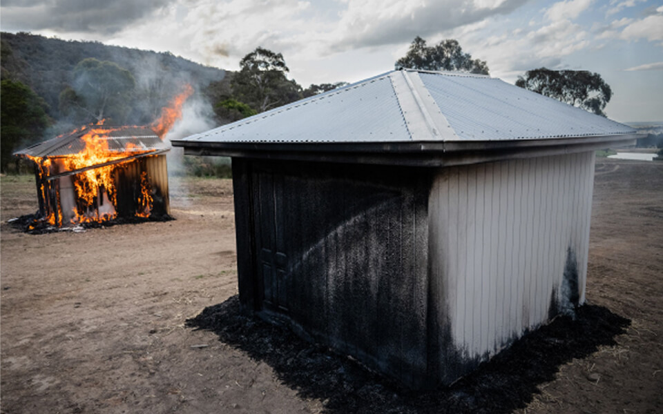 Photo of a burning shed and a burned shed Photo of a burning shed and a burned shed