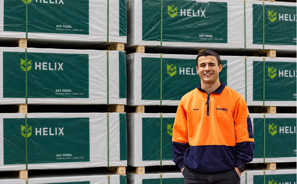 Photo of a smiling man in a warehouse with Helix branded packages behind him